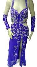 A mannequin displaying a professional belly dance costume with a purple color, featuring glass beads and sequins decorations, a front slit skirt, and a headband.