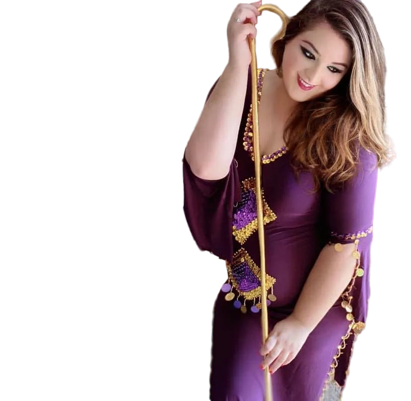 Woman in a purple dress with gold accents holding a decorative staff on a white background