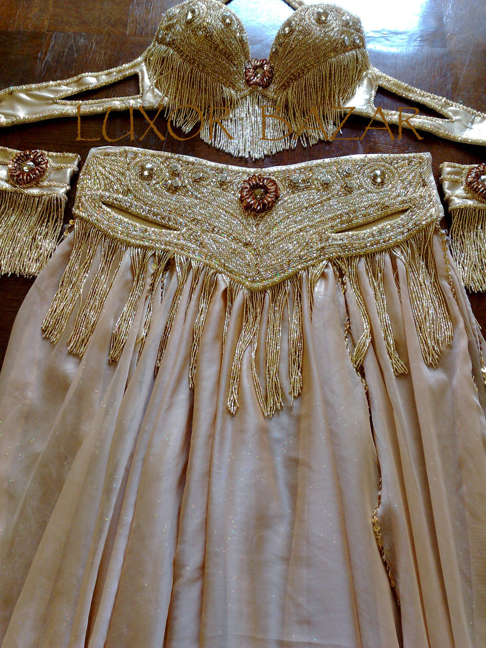 A professional Egyptian belly dance costume featuring a richly decorated belt with glass stones and sequins, in addition to a skirt made of chiffon and lycra fabric.