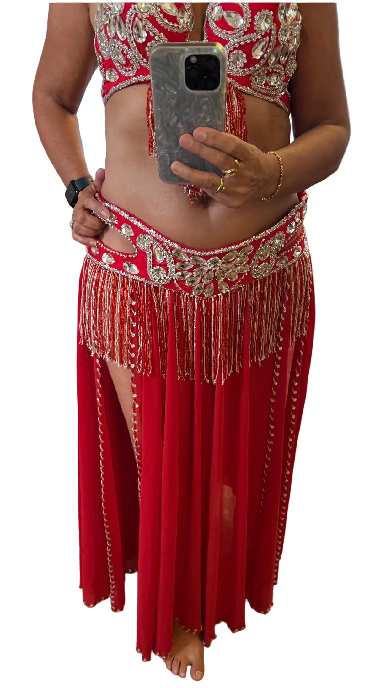 Person wearing a red outfit with intricate designs and fringes, taking a mirror selfie.