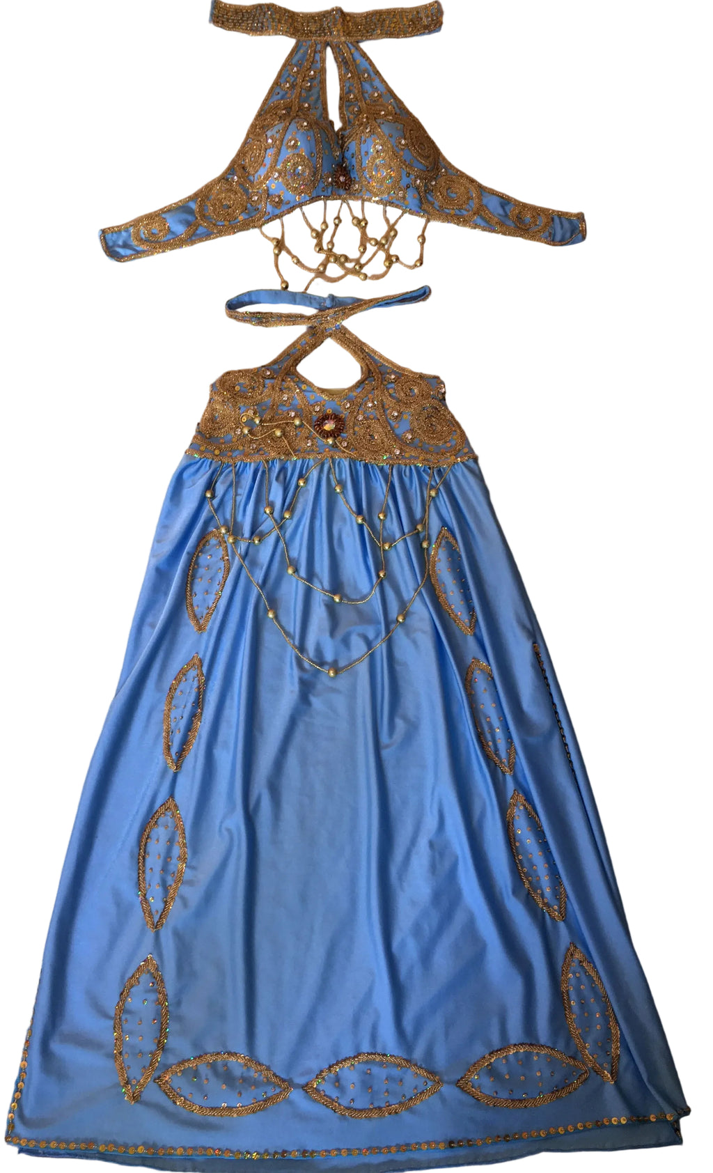 A professional belly dance costume laid out on a flat surface, featuring a blue skirt with gold embellishments, a matching top with a neckline, and a pair of sleeves.