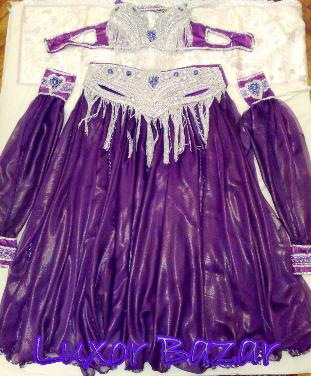 A professional Egyptian belly dance costume featuring a richly decorated belt with glass stones and sequins, in addition to a skirt made of chiffon and lycra fabric.