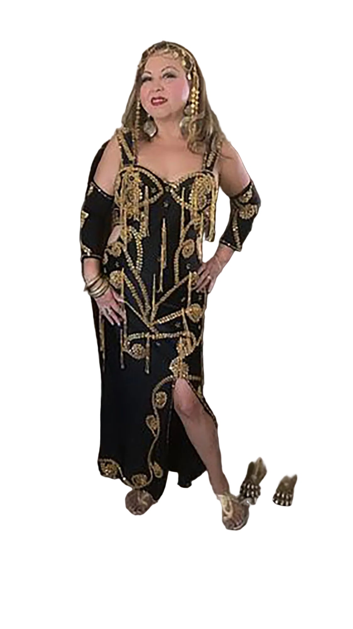 Woman in a black and gold dress standing in an elegant room with decorative elements.