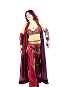Woman wearing a burgundy belly dancing costume with intricate designs on a white background