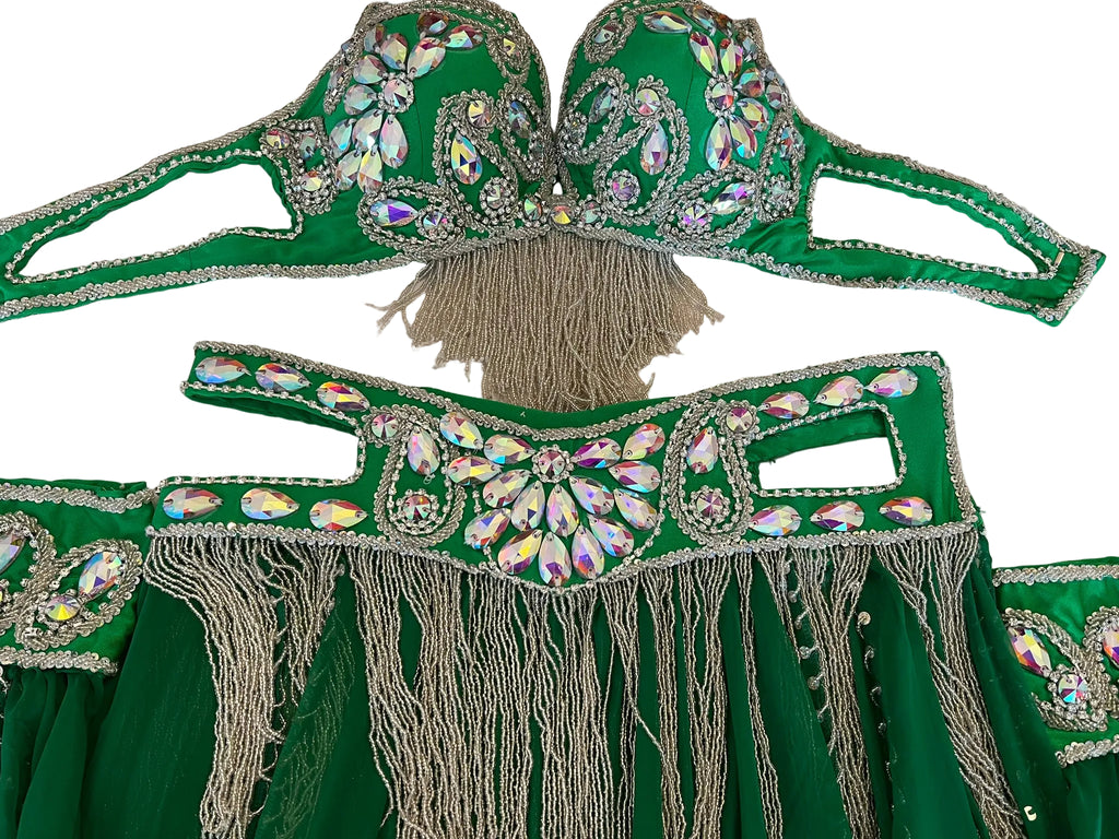 Green costume with embellishments and fringes on a white surface