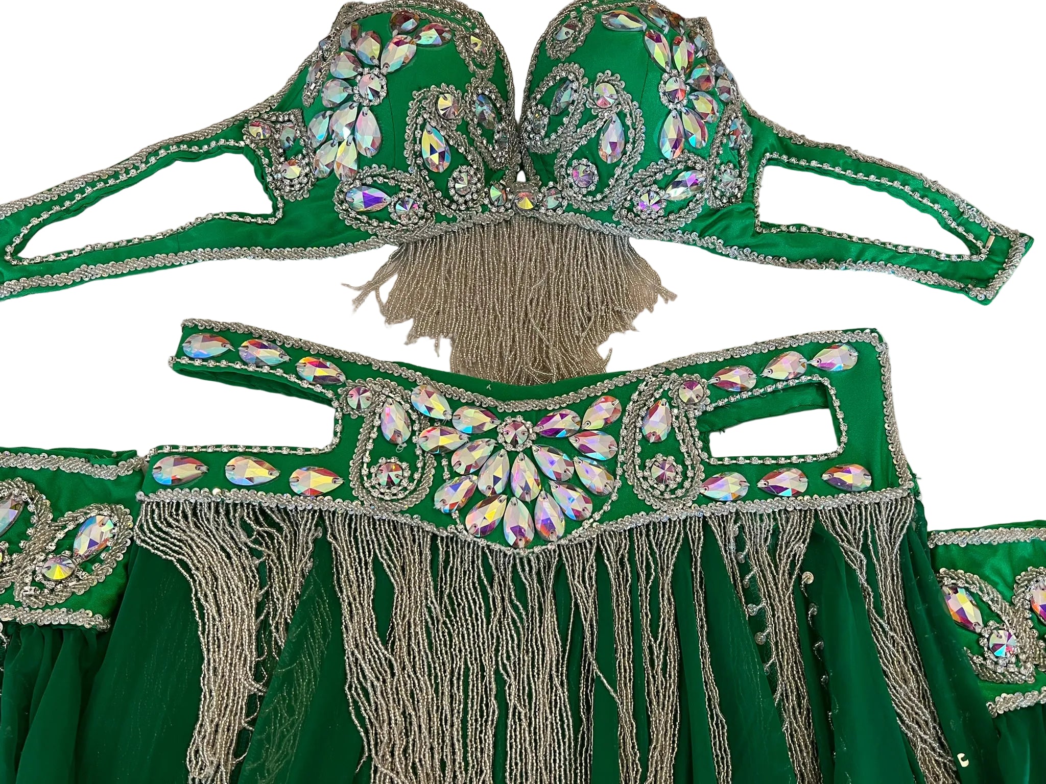 Green costume with embellishments and fringes on a white surface