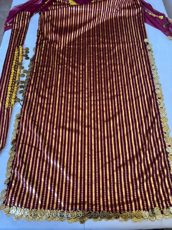 An Egyptian belly dance dress with black and silver stripes and embroidery, featuring a V-neckline and sleeveless design.