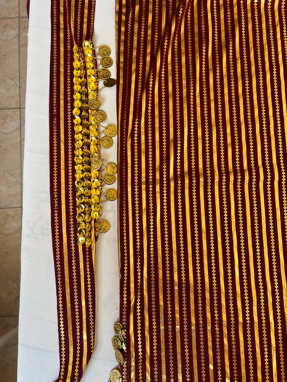 An Egyptian belly dance dress with black and silver stripes and embroidery, featuring a V-neckline and sleeveless design.