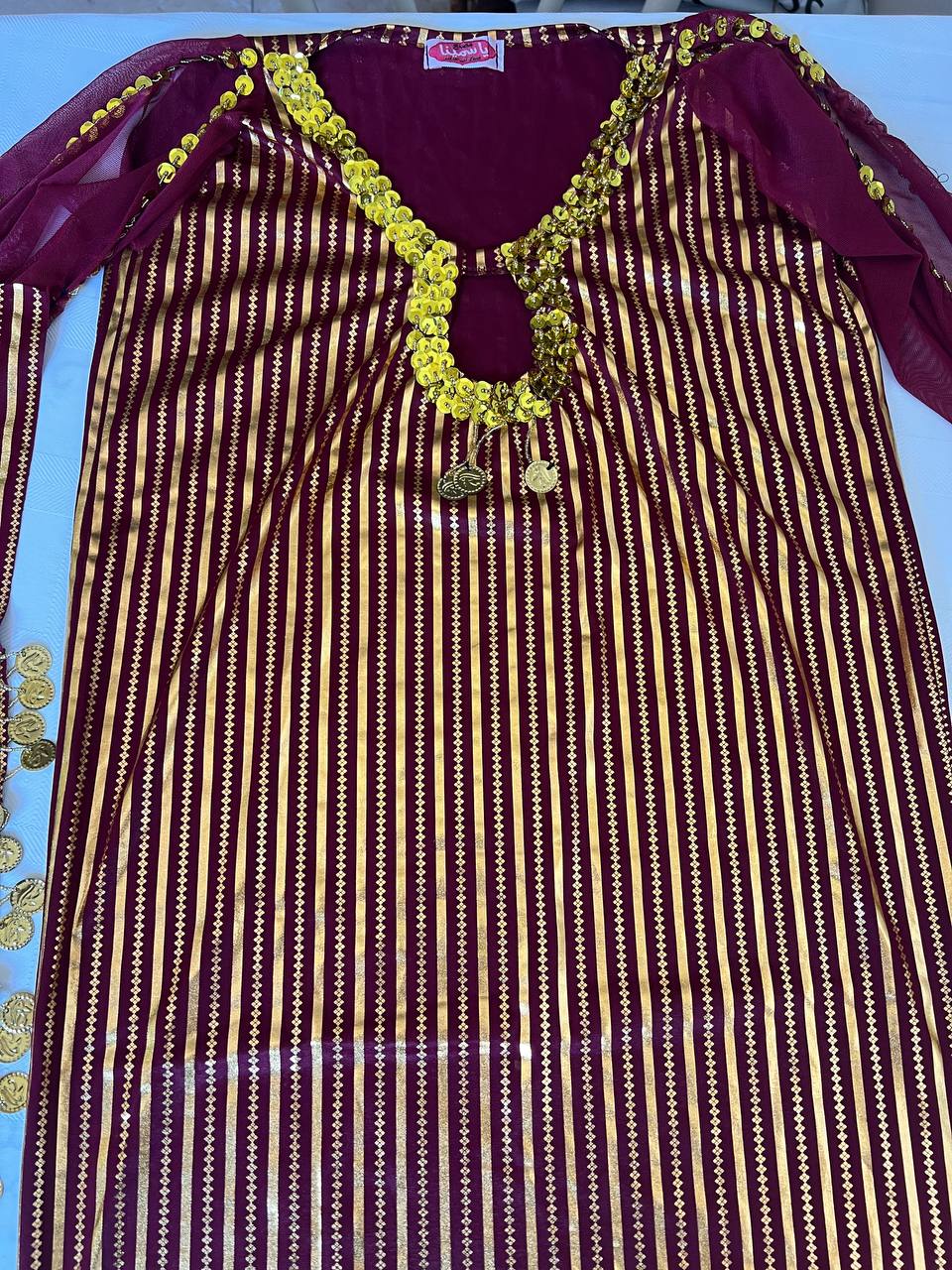 An Egyptian belly dance dress with black and silver stripes and embroidery, featuring a V-neckline and sleeveless design.