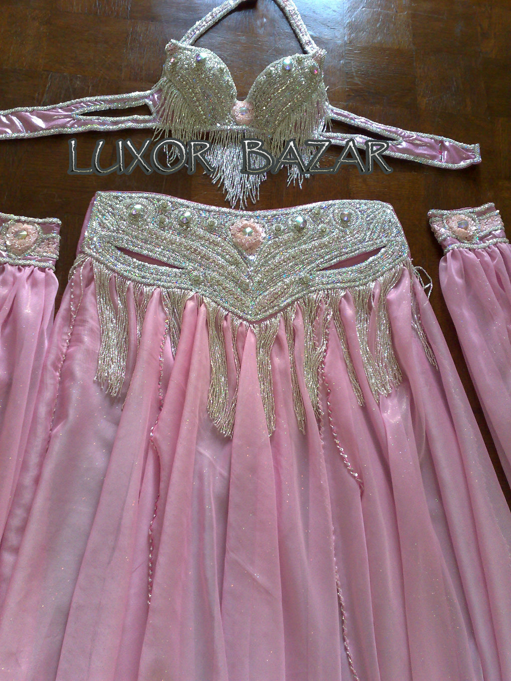 A professional Egyptian belly dance costume featuring a richly decorated belt with glass stones and sequins, in addition to a skirt made of chiffon and lycra fabric.
