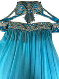 A professional Egyptian belly dance costume with a blue chiffon skirt, attached bra belt with gold-colored embellishments, and a pair of arm pieces with decorative sleeve patterns.