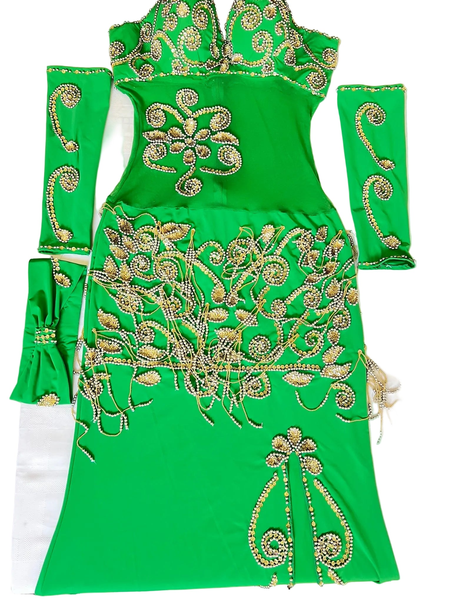 A bright green belly dance dress with intricate gold embellishments, including arm pieces and a headpiece.