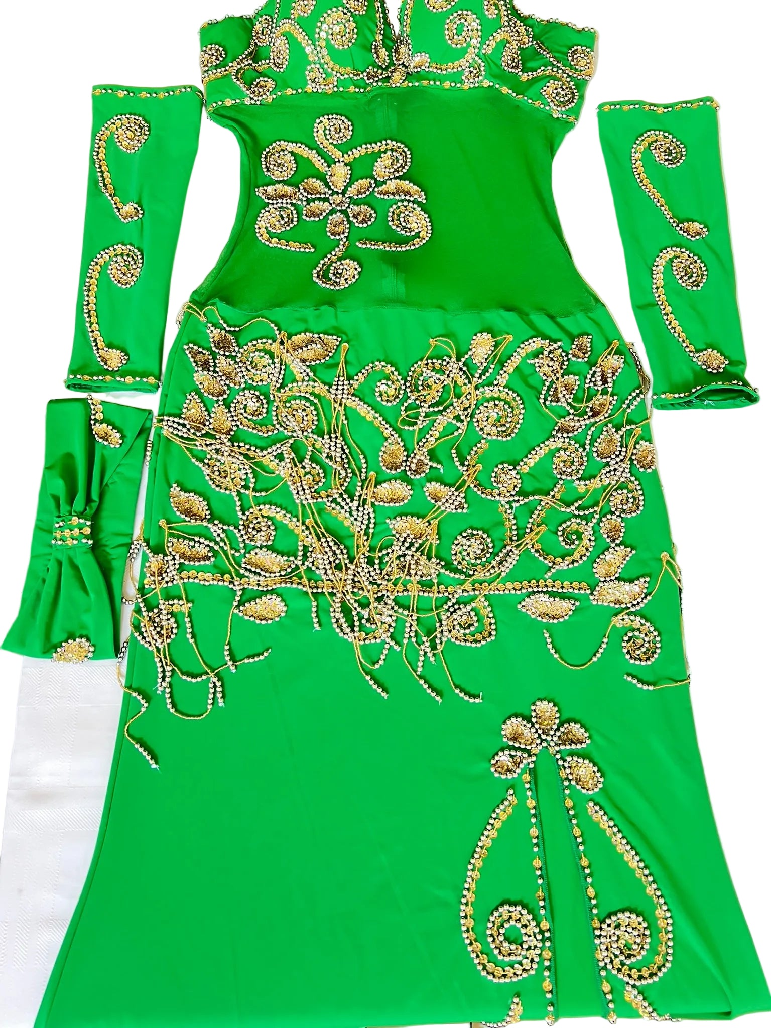 Green embroidered dress with gold patterns on a white surface