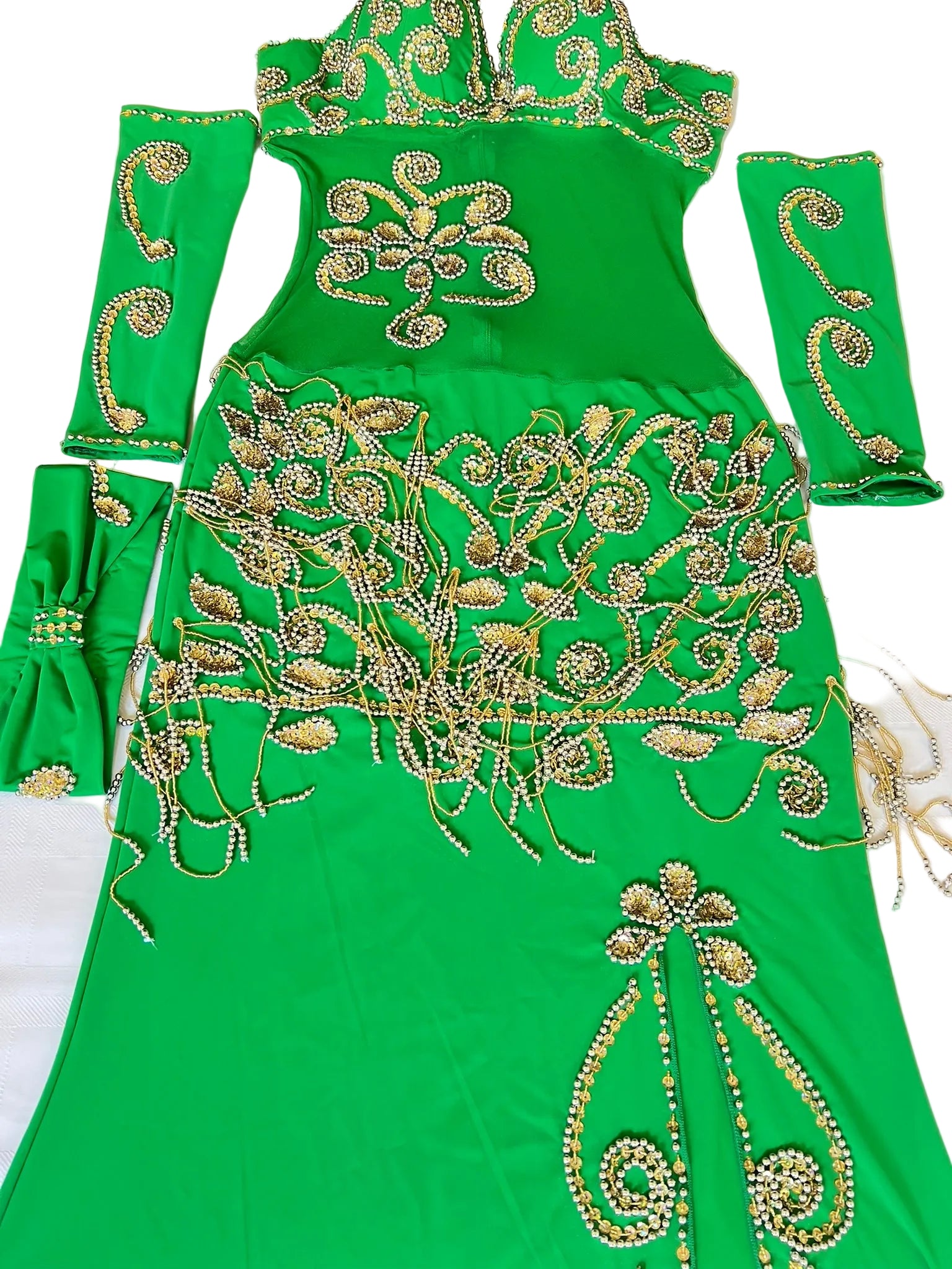 Green dress with gold embroidery on a white surface