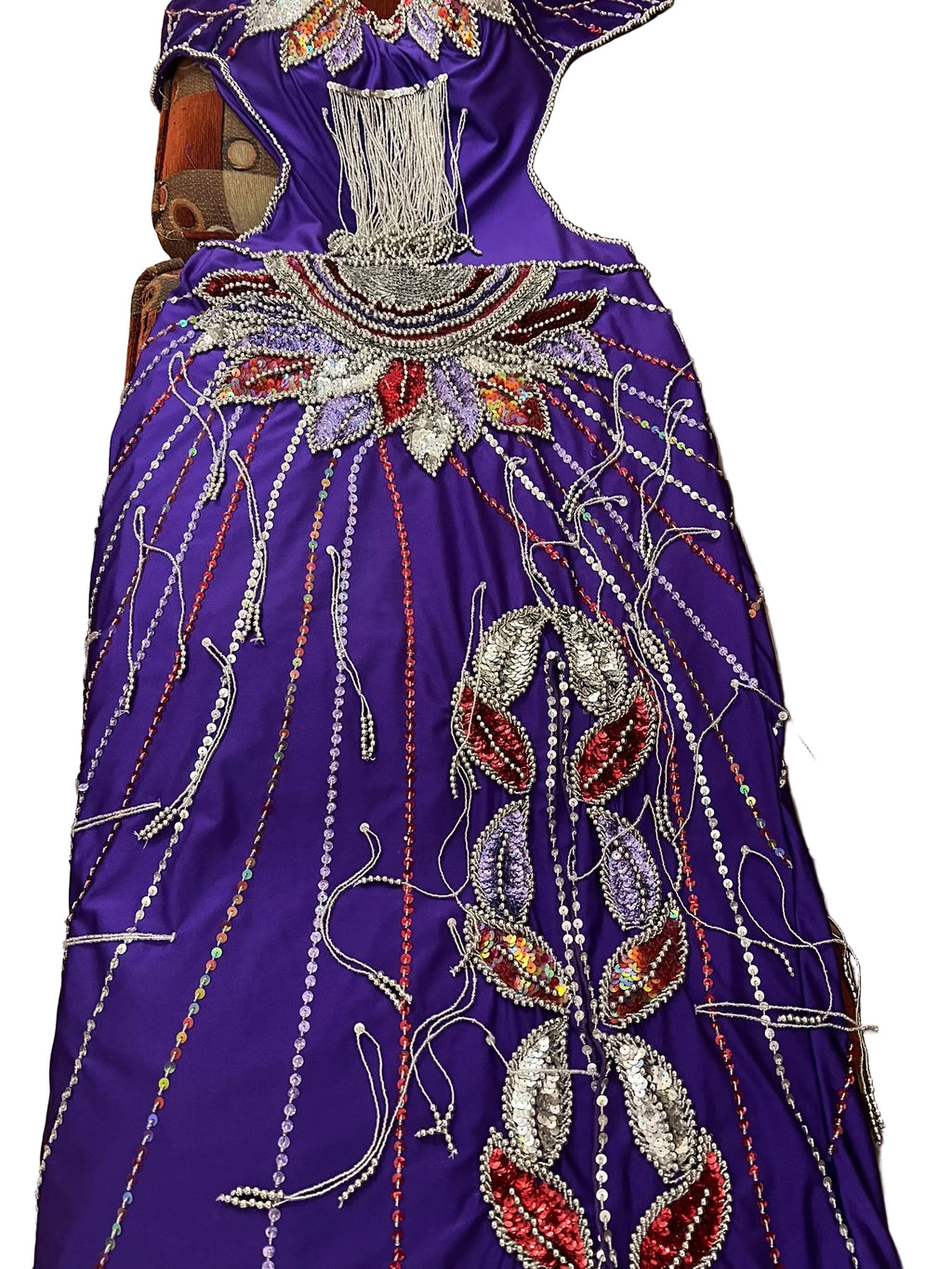 A vibrant royal purple belly dance costume with intricate beadwork and sequins in multiple colors.