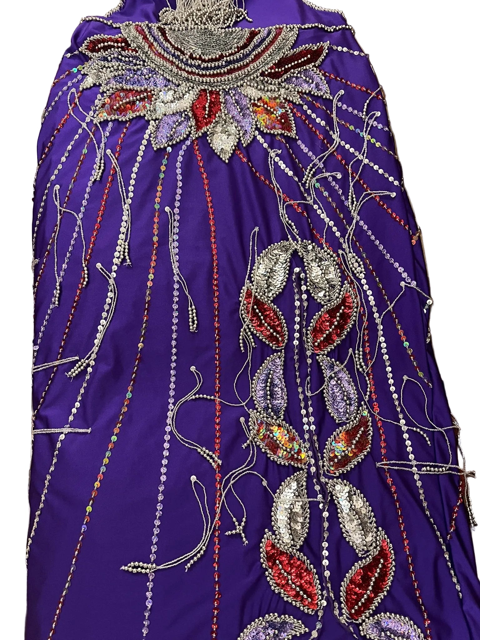 Decorative purple fabric with intricate beadwork on a patterned chair.