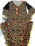 A leopard print belly dance dress with handmade embellishments, displayed on a flat surface.