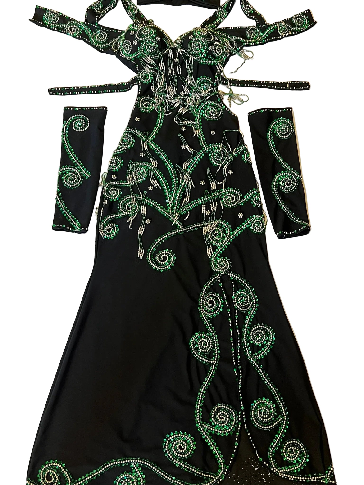 An elegant belly dance ensemble featuring a black one-piece dress with intricate green embellishments, including glass beads and sequins, with sleeves and a headpiece.