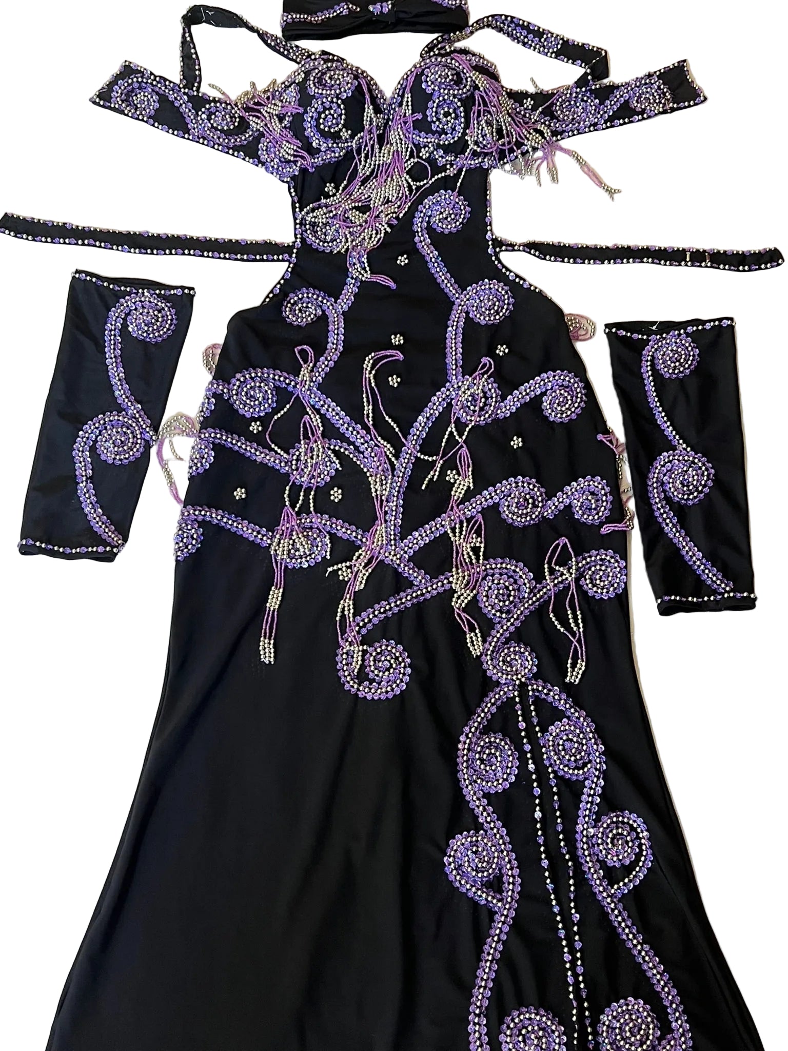 A custom-made belly dance costume featuring a one-piece dress with arm pieces and a headpiece, embellished with purple glass beads and sequins on a black background.