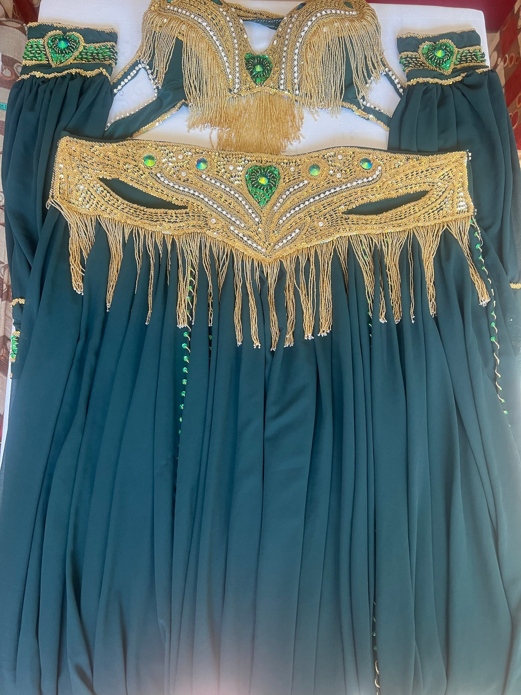 A professional Egyptian belly dance costume featuring a richly decorated belt with glass stones and sequins, in addition to a skirt made of chiffon and lycra fabric.