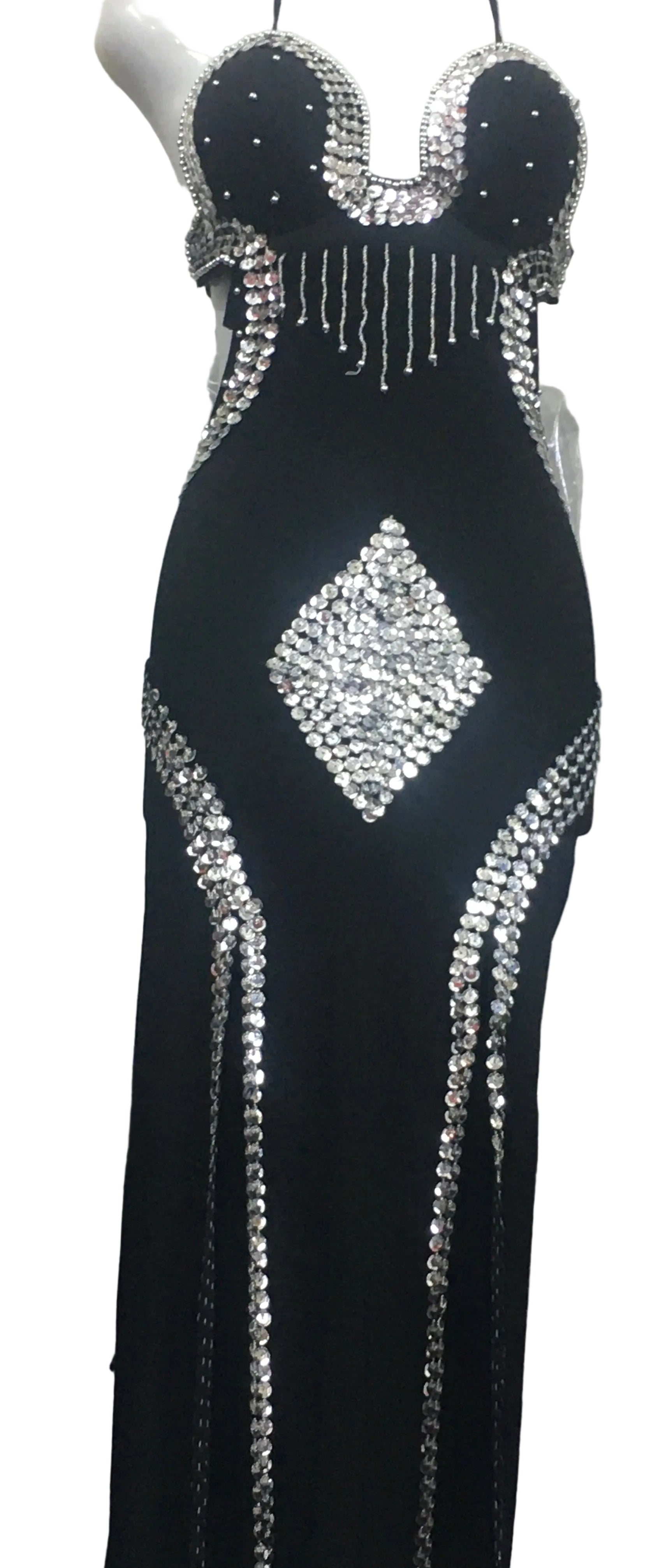 A black belly dance dress with embellished handmade bead embroidery, featuring a bra-like top and a flowing skirt, displayed on a mannequin.