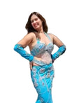 A person wearing a stunning turquoise blue Egyptian belly dance costume with embroidery, consisting of a skirt, bra, sleeves, and a headband.