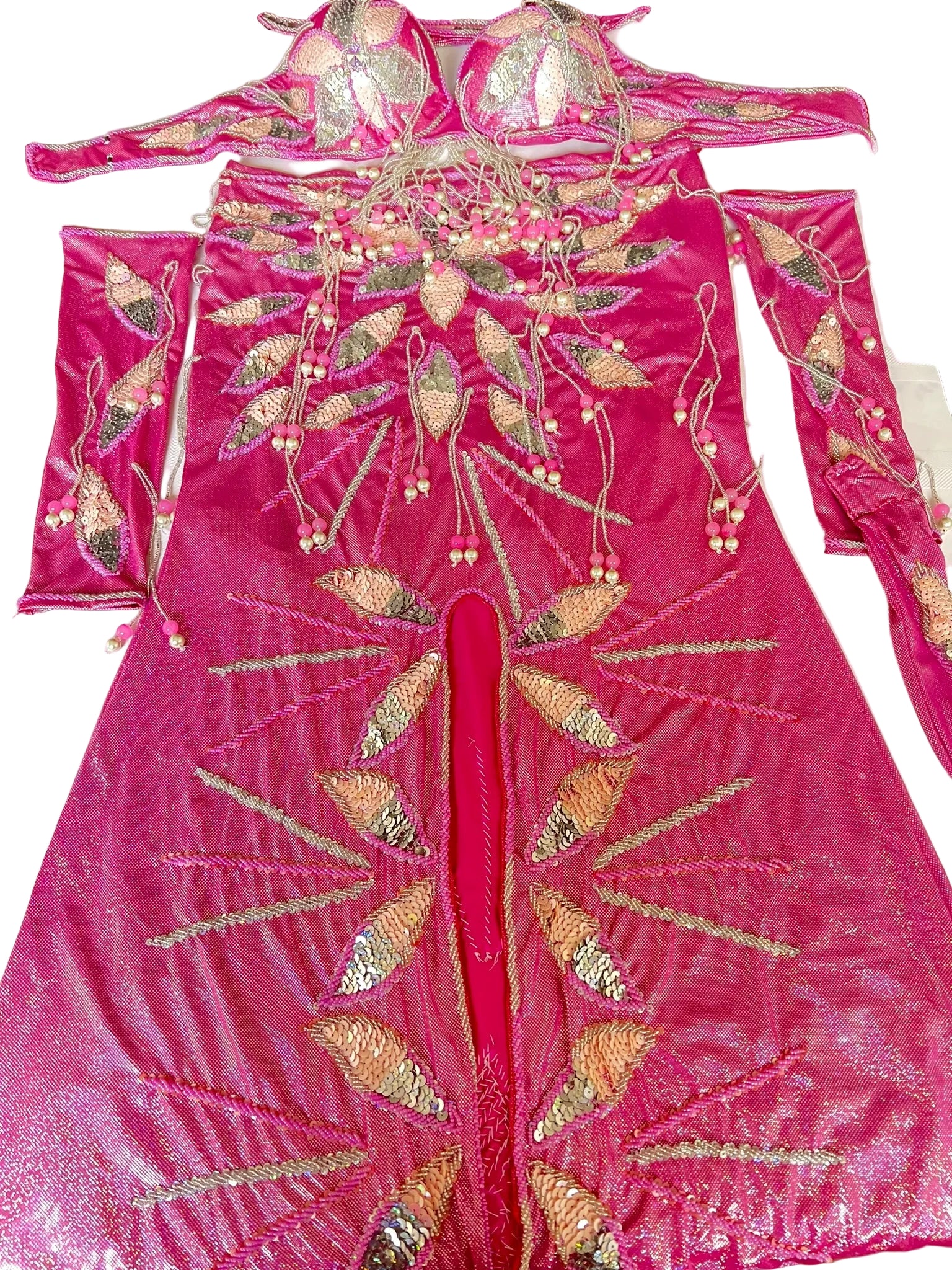 Pink embroidered traditional outfit on a white surface