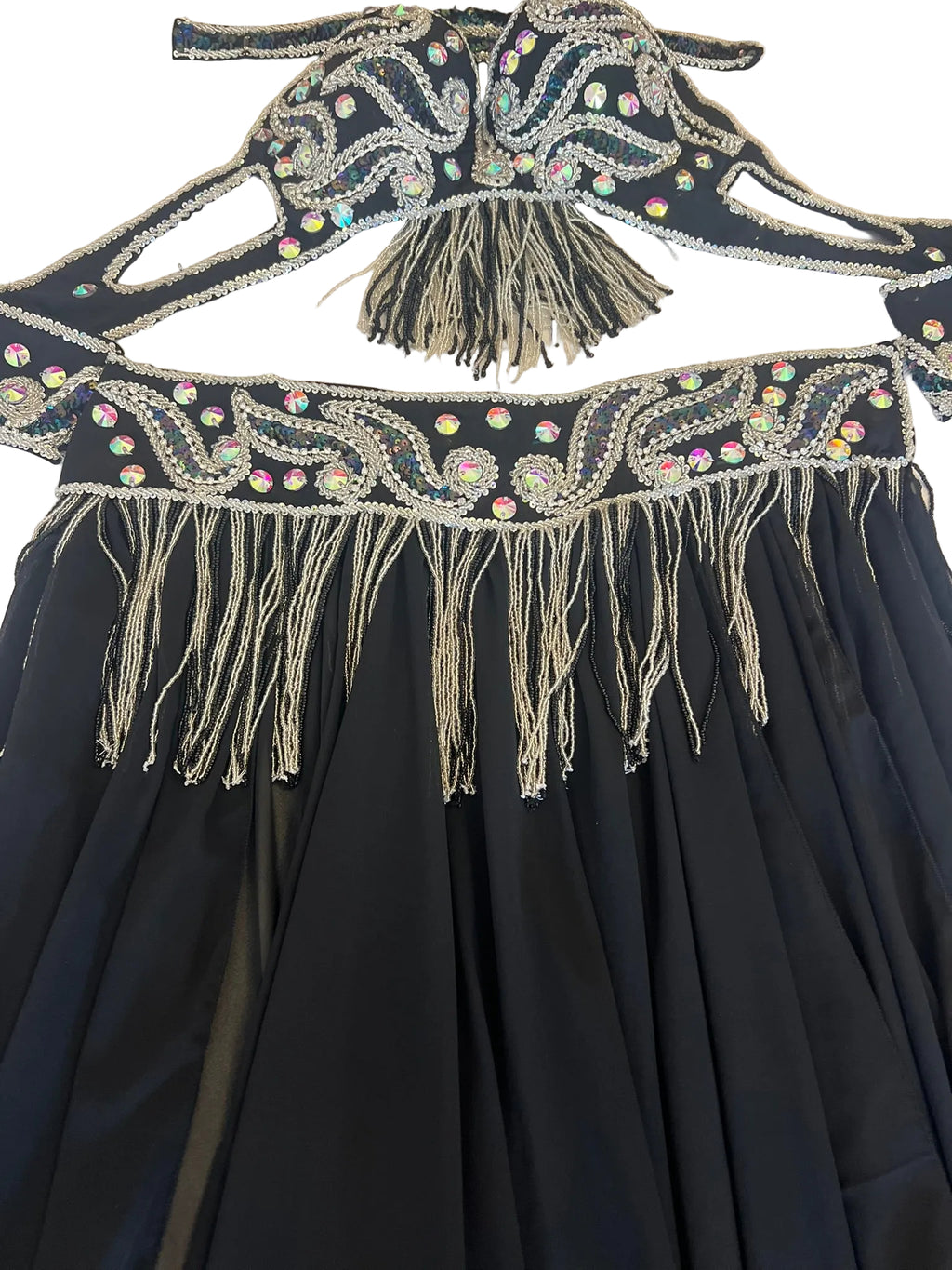 Black dress with intricate beadwork and fringes on a white background