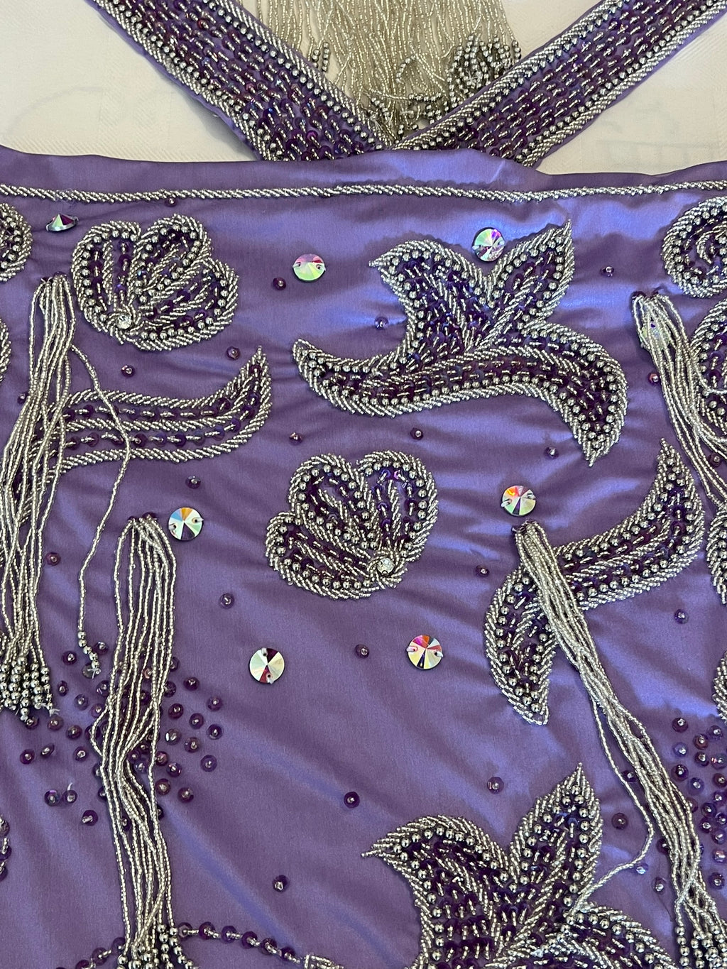 Purple embellished belly dance costume on a white surface