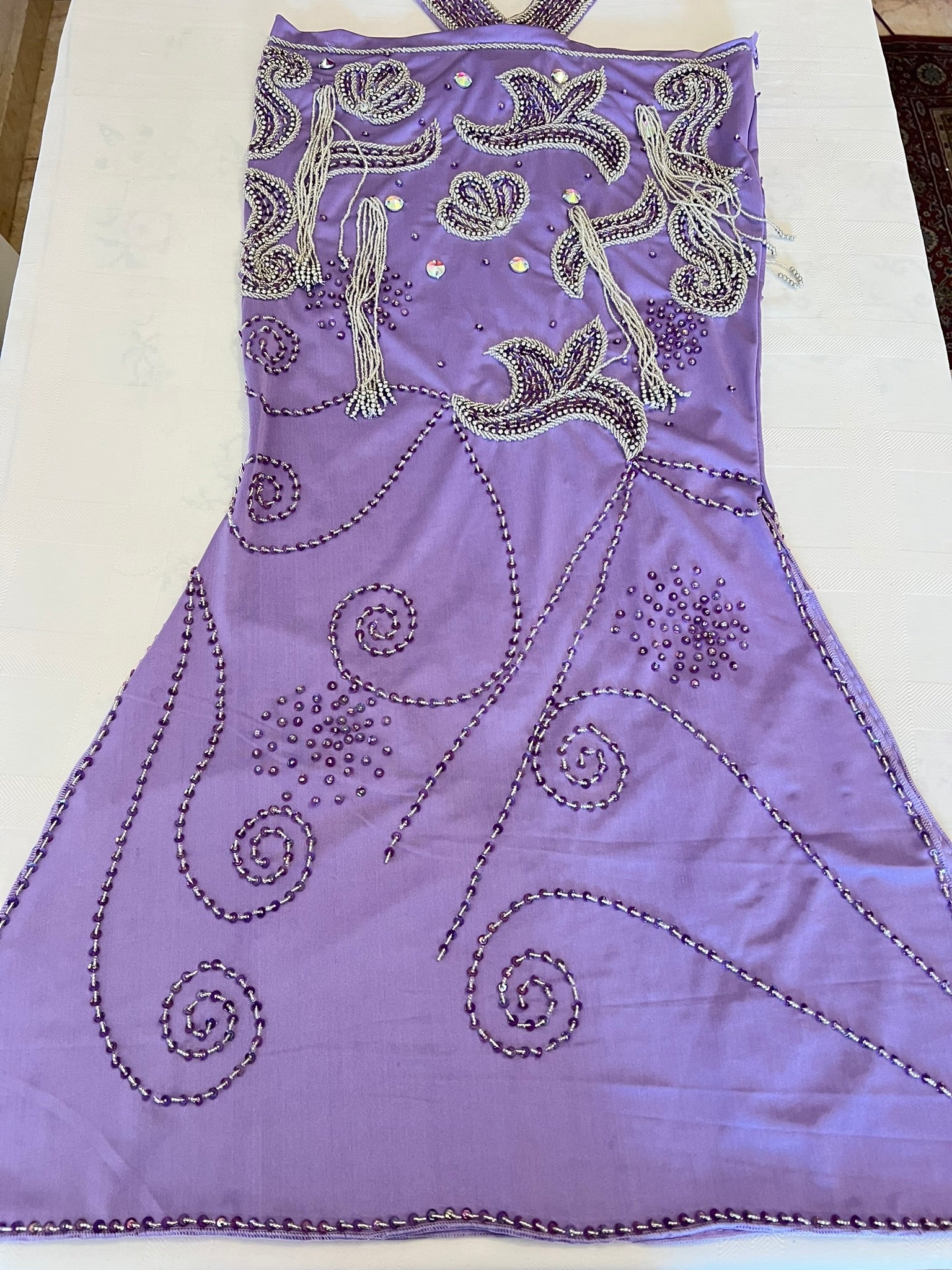 Purple belly dance dress with intricate silver beading on a white background