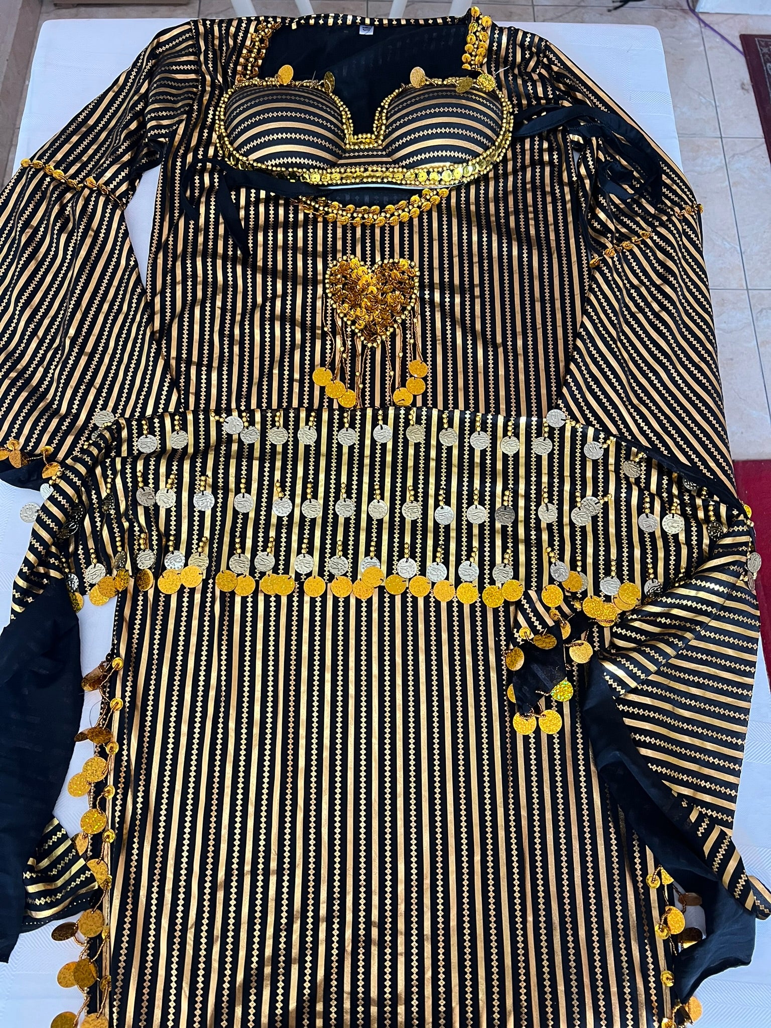 Black and gold traditional outfit with intricate patterns on a white background