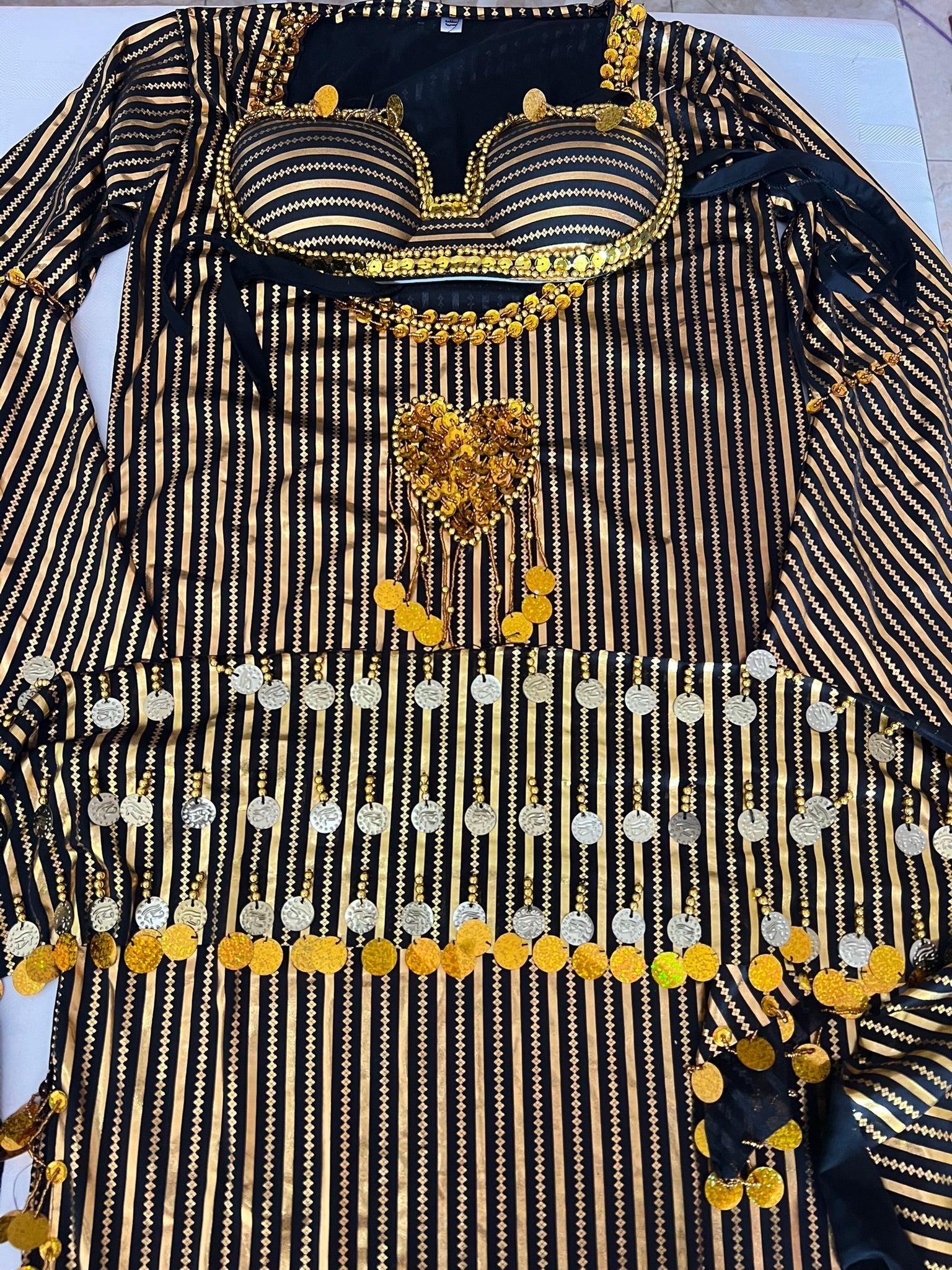 Black and gold embroidered traditional outfit on a white background