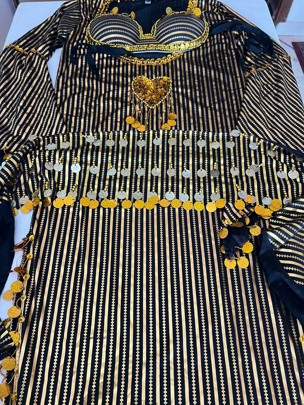 Black and gold embroidered garment on a white surface