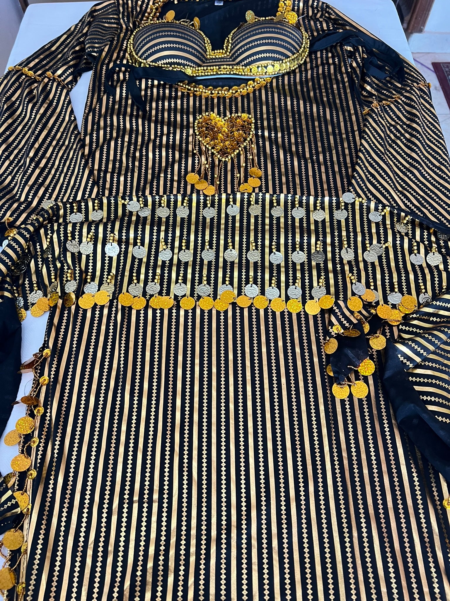 Black and gold embroidered garment on a white surface
