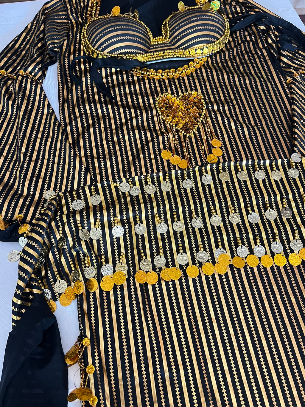 Black and gold traditional outfit with decorative elements on a white background