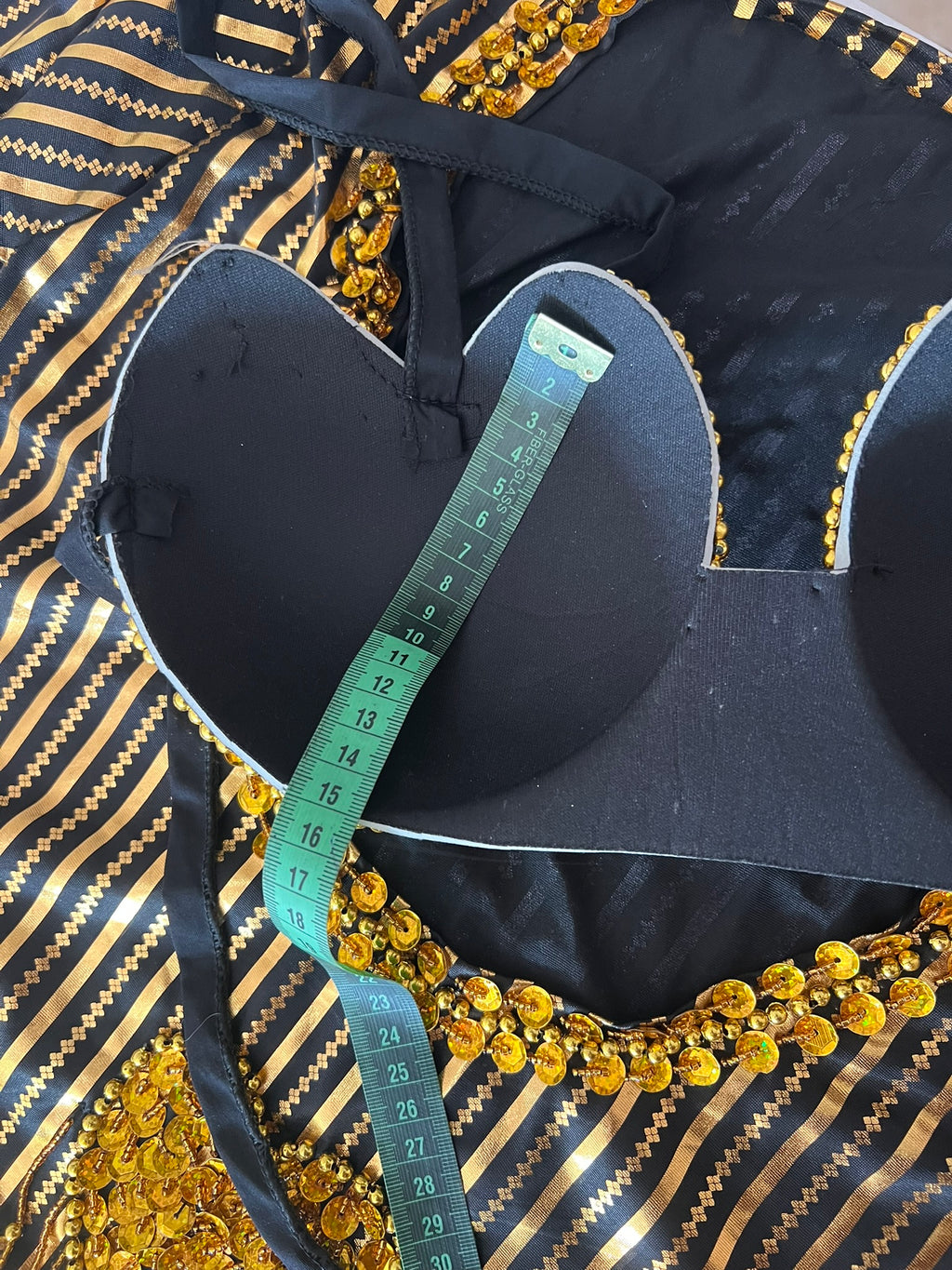 Black and gold decorative item with a measuring tape on top
