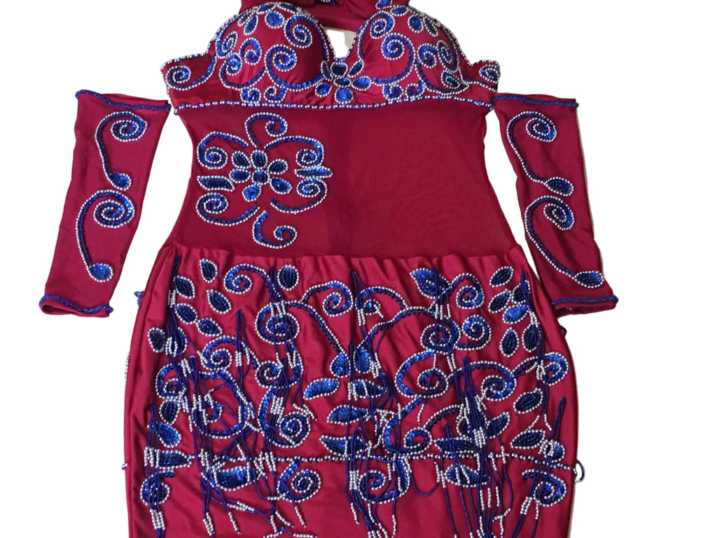 Red traditional outfit with blue embroidery on a beige surface