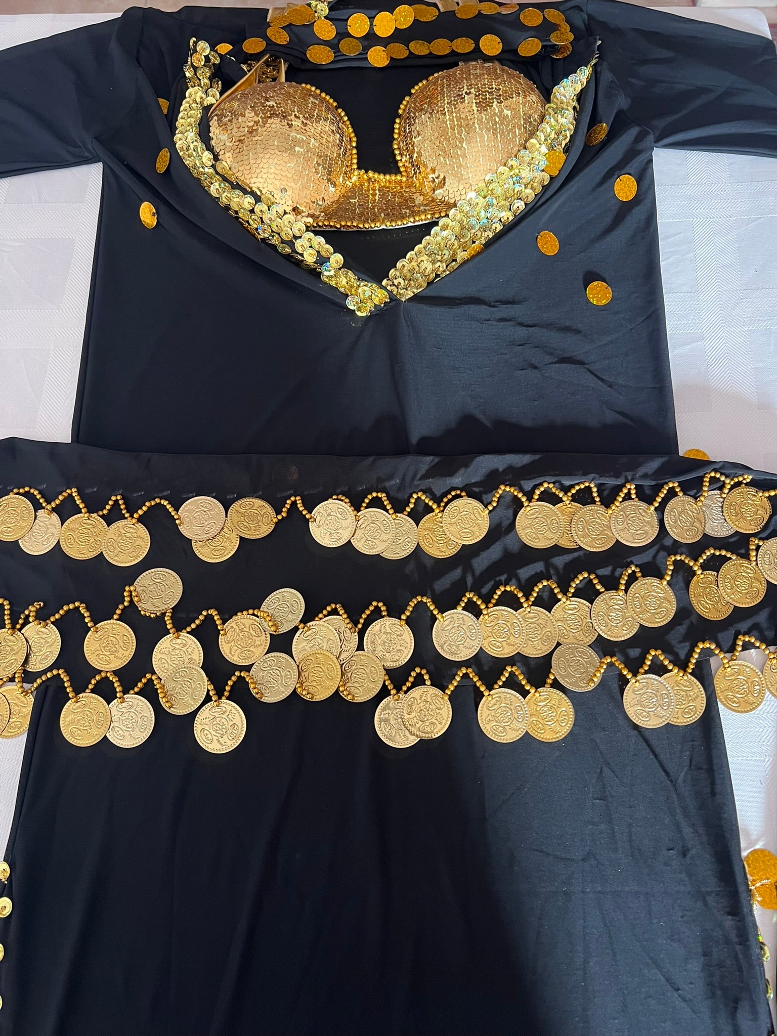 Black garment with gold embellishments on a white background