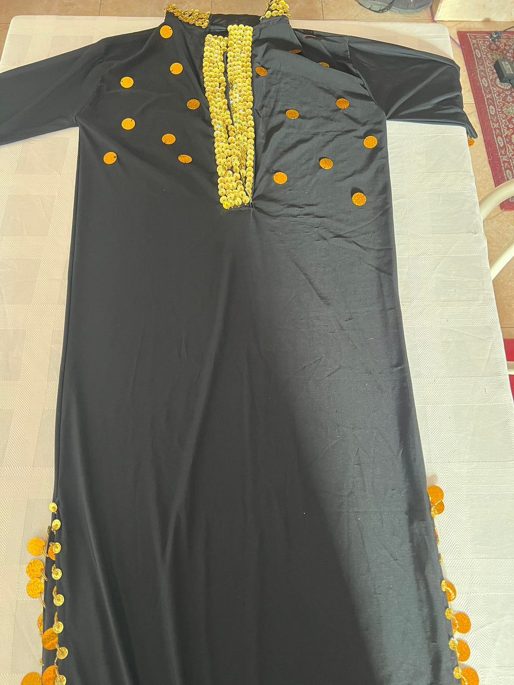 Gray dress with yellow embellishments on a white surface
