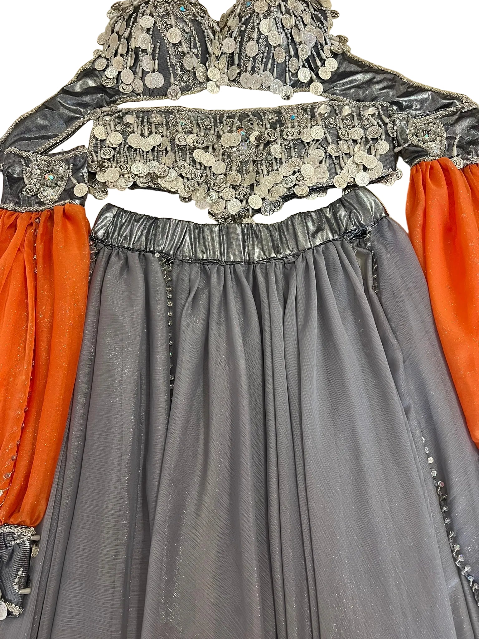 Gray traditional outfit with silver embellishments and orange fabric on a beige surface