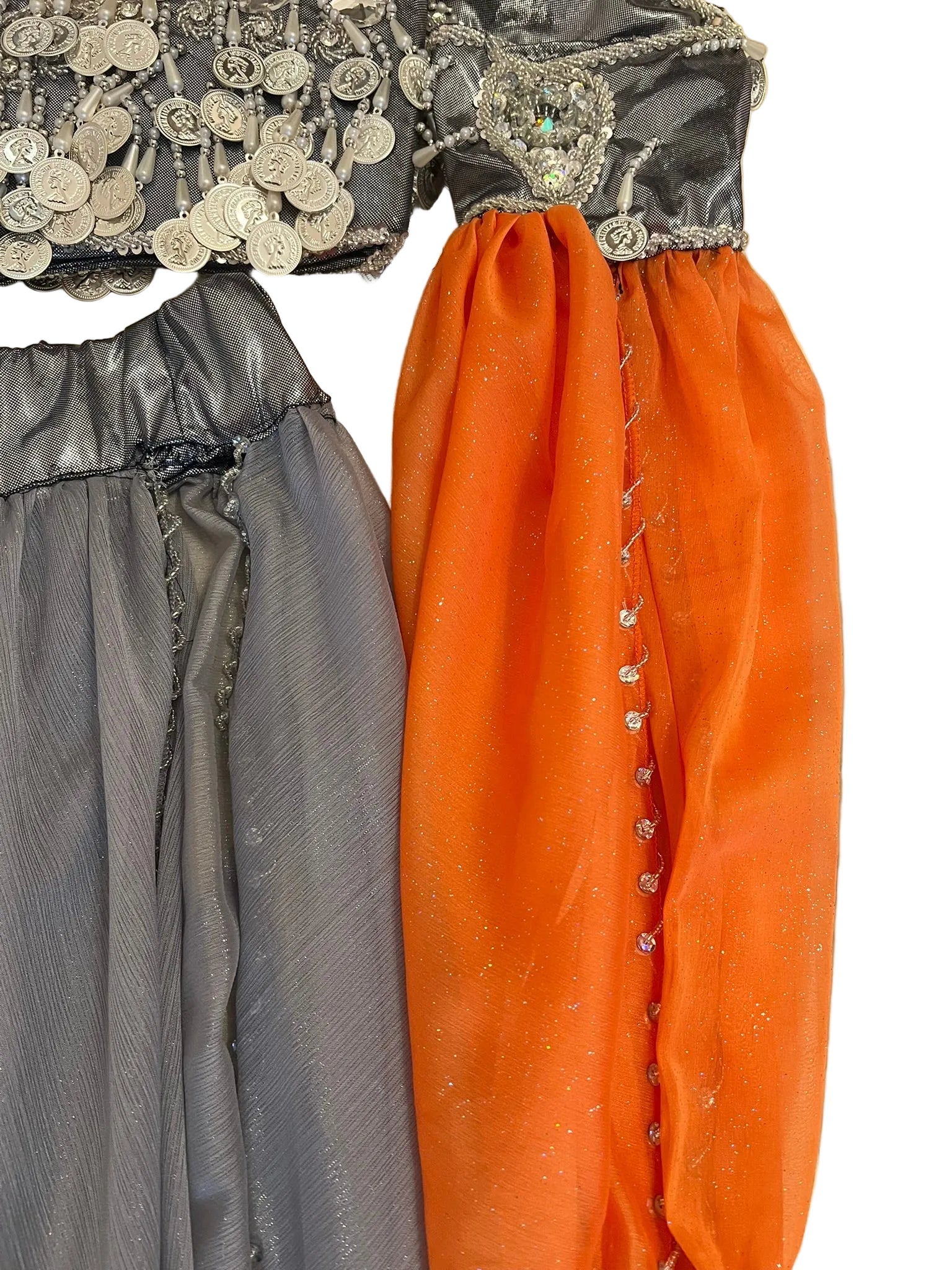 Gray and orange pants with decorative elements on a beige wall.