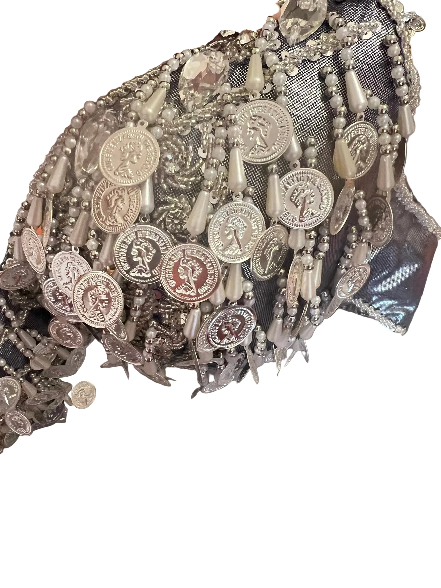 Close-up of a decorative headpiece with coins and beads on a plain background