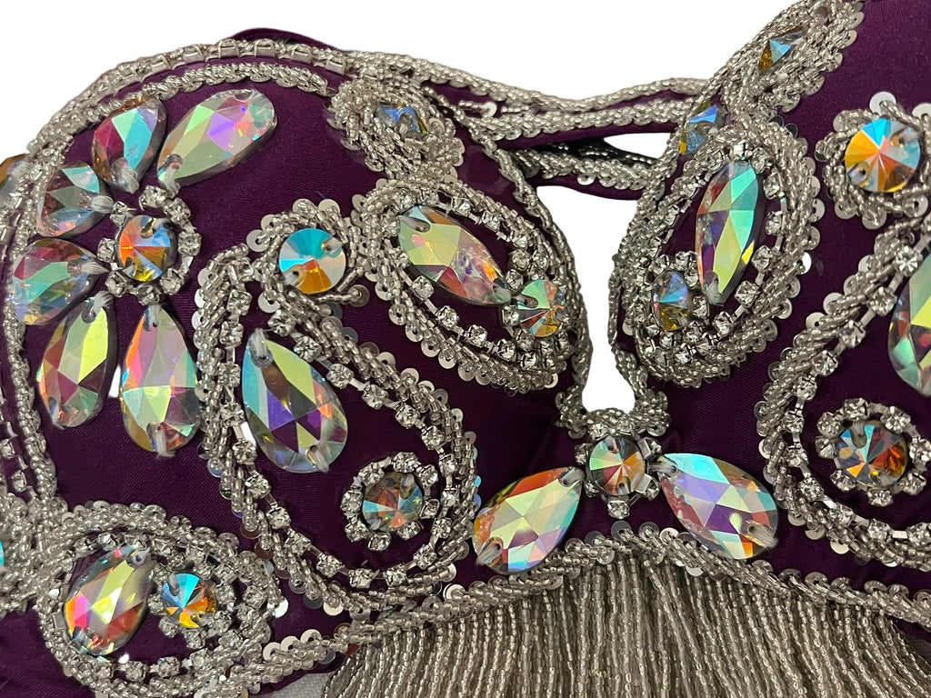 Decorative Belly dance bra with rhinestones on a purple background