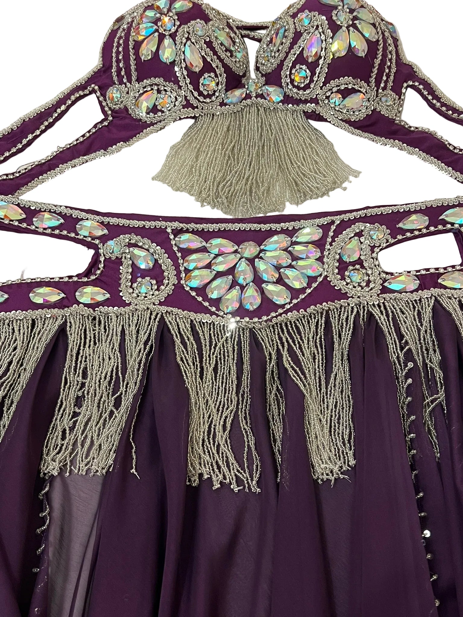 Purple garment with intricate silver embroidery and tassels on a white background