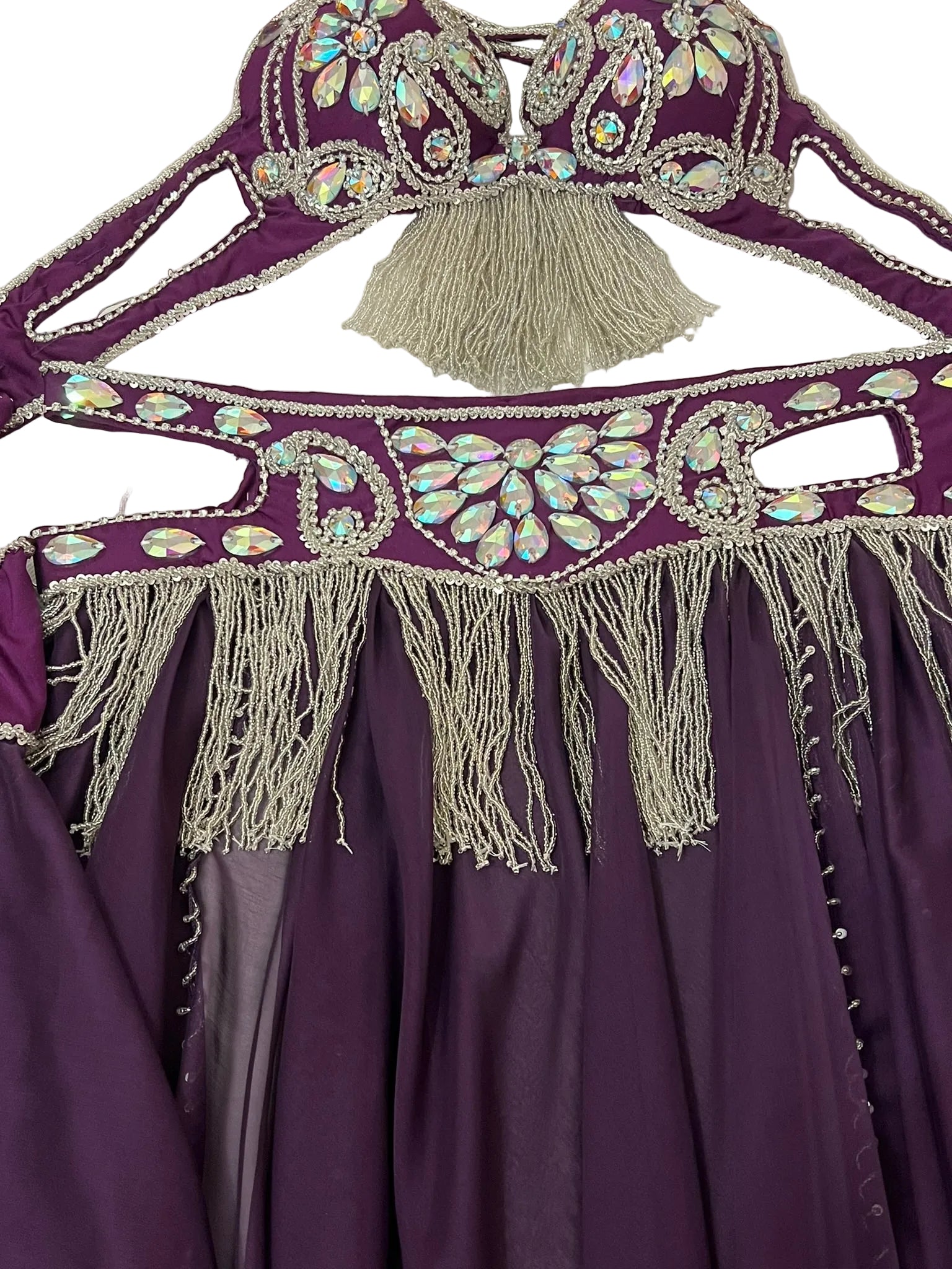 Purple garment with intricate beading and tassels on a white background