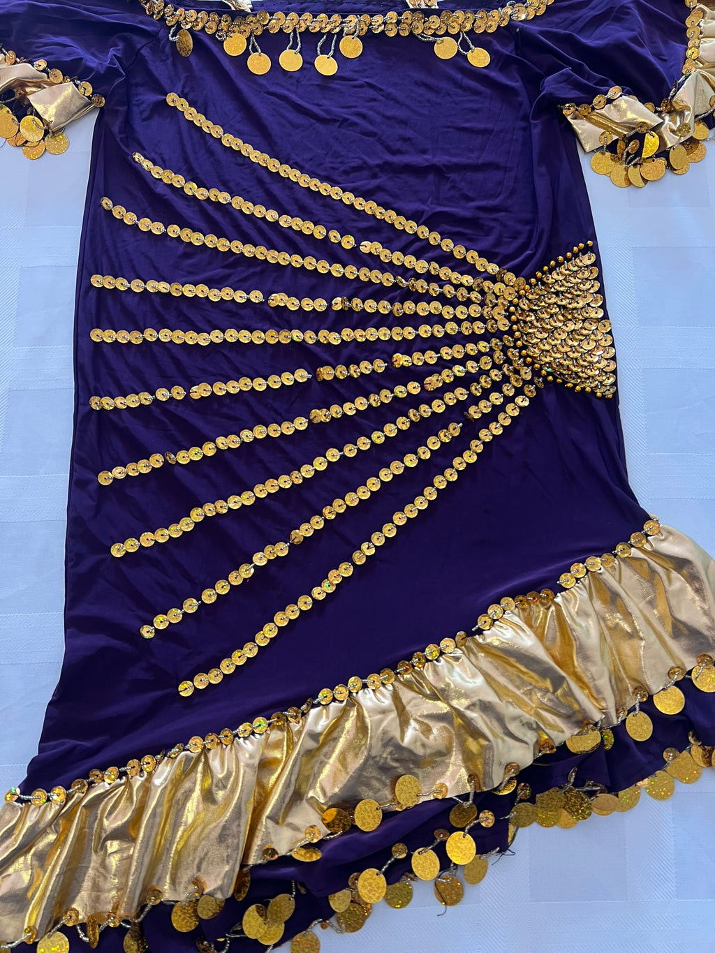 Navy blue dress with gold embellishments on a light blue background