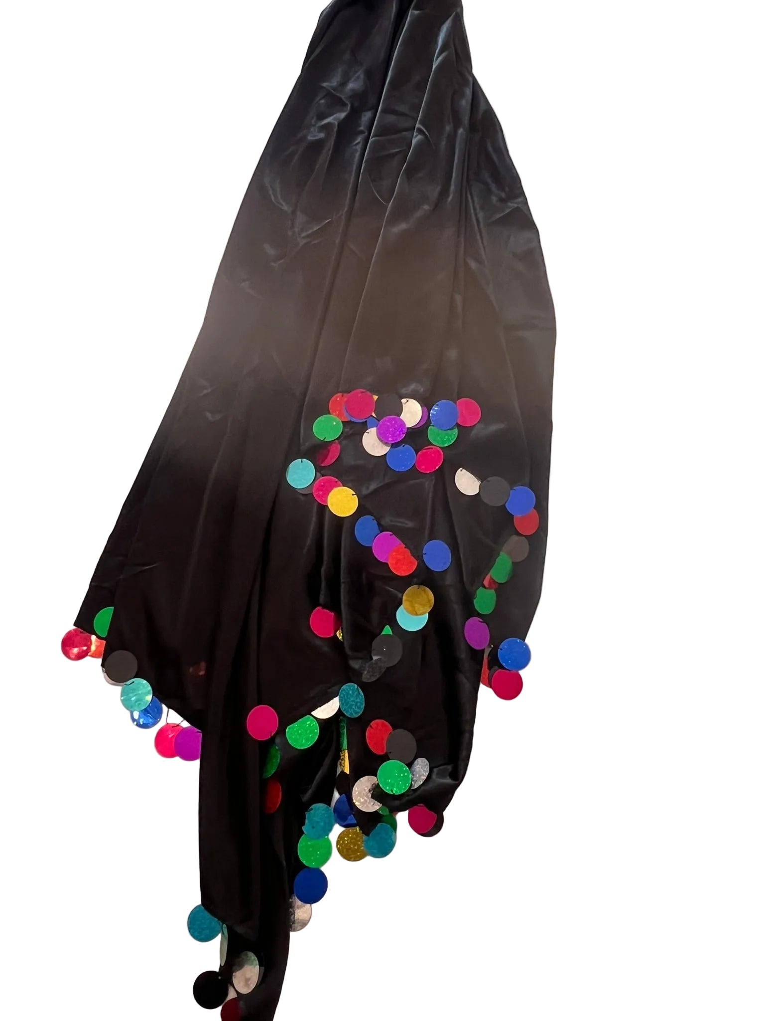 Black fabric with colorful pom-poms on a light wooden floor