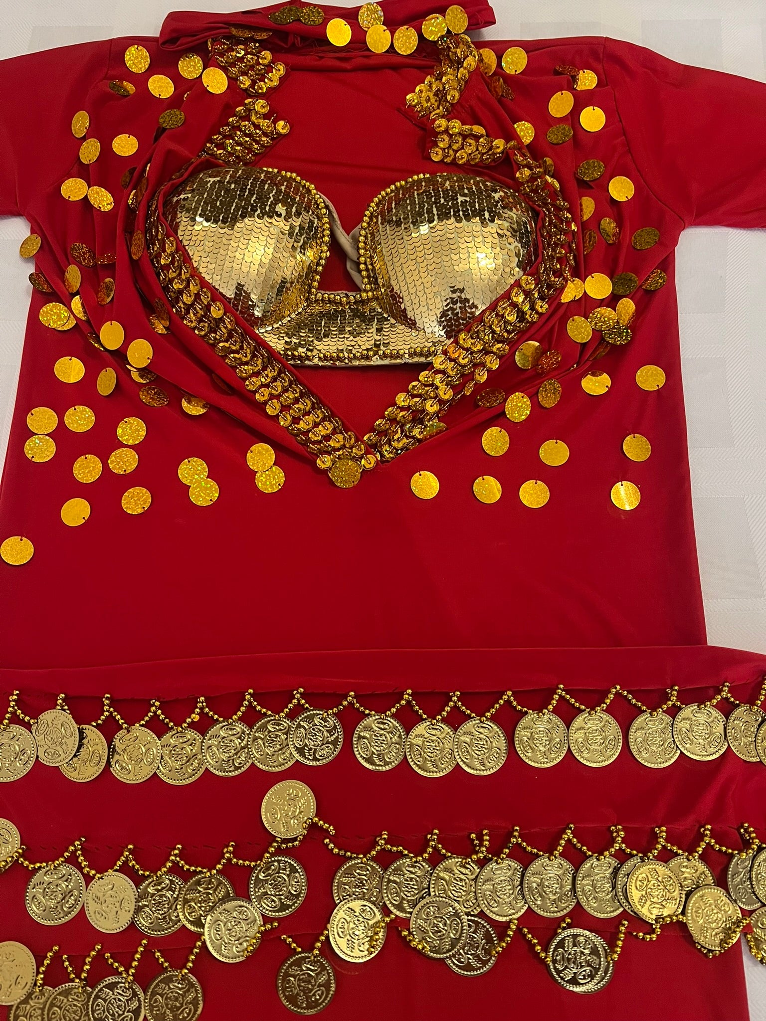 Red outfit with gold embellishments including a bra and coins on a white background