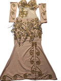 Beige evening gown with gold embroidery on a patterned surface