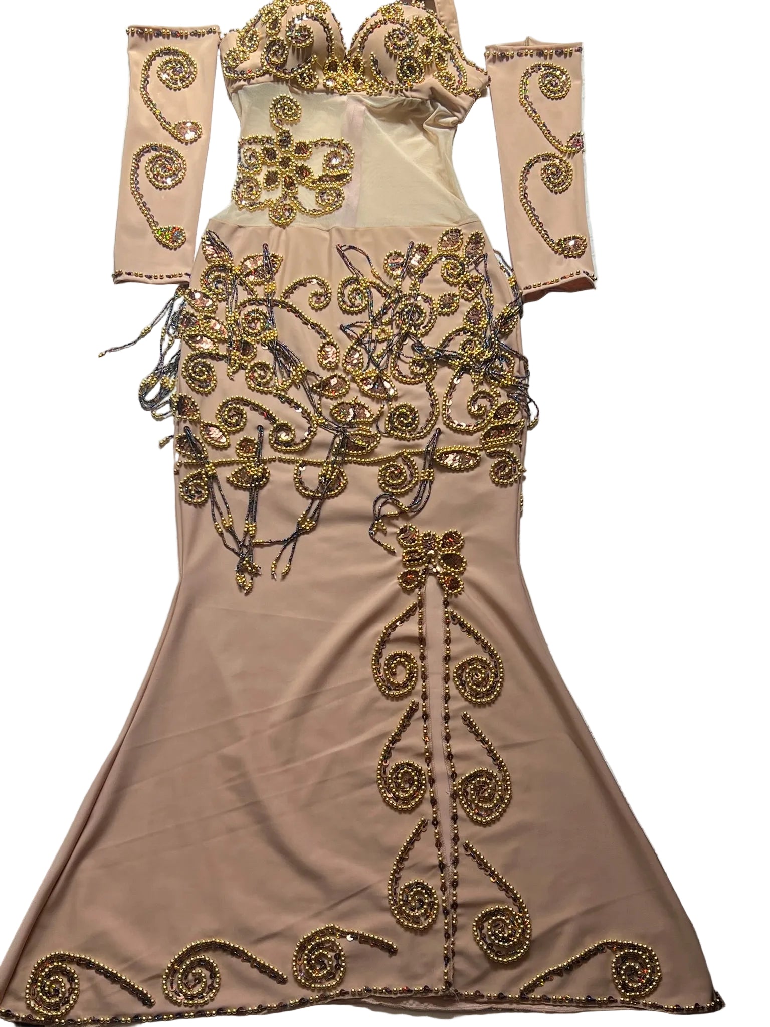 Beige evening gown with gold embroidery on a patterned surface